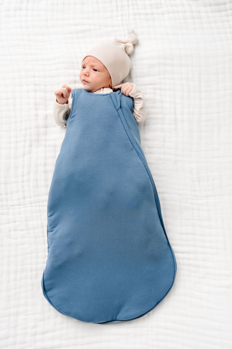 dean sleep sack newborn boy laying on bed newborn size