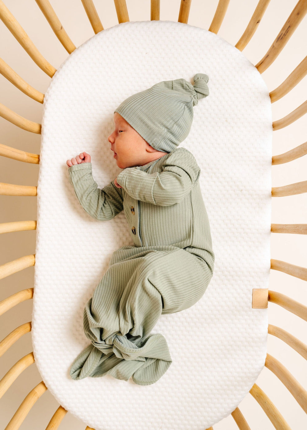 Ellis Knotted gown with top knot hat. Baby newborn boy in green knotted gown laying in a bassinet 