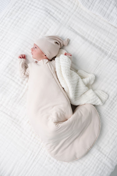 cove sleep sack newborn boy laying on bed