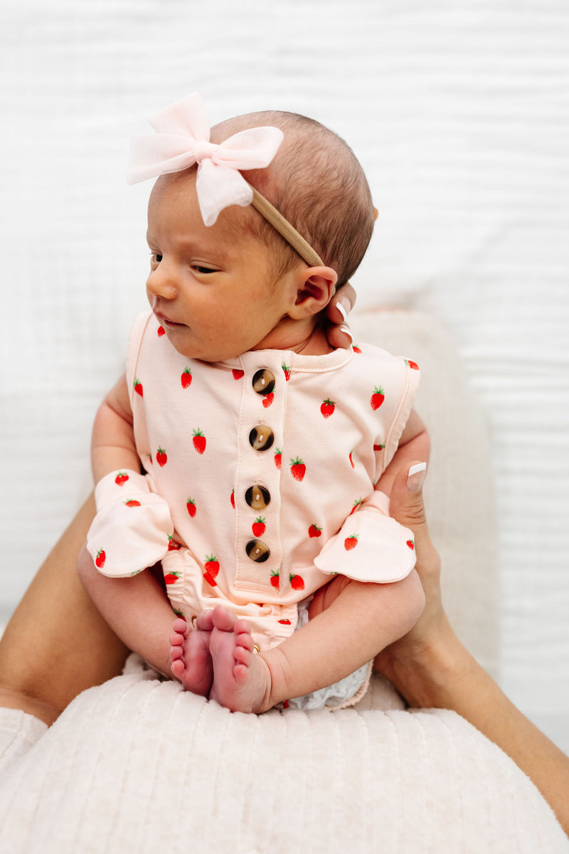 Junie Bubble Romepr Newborn girl with mittens and blush tulle bow nylon headband. being held by mom