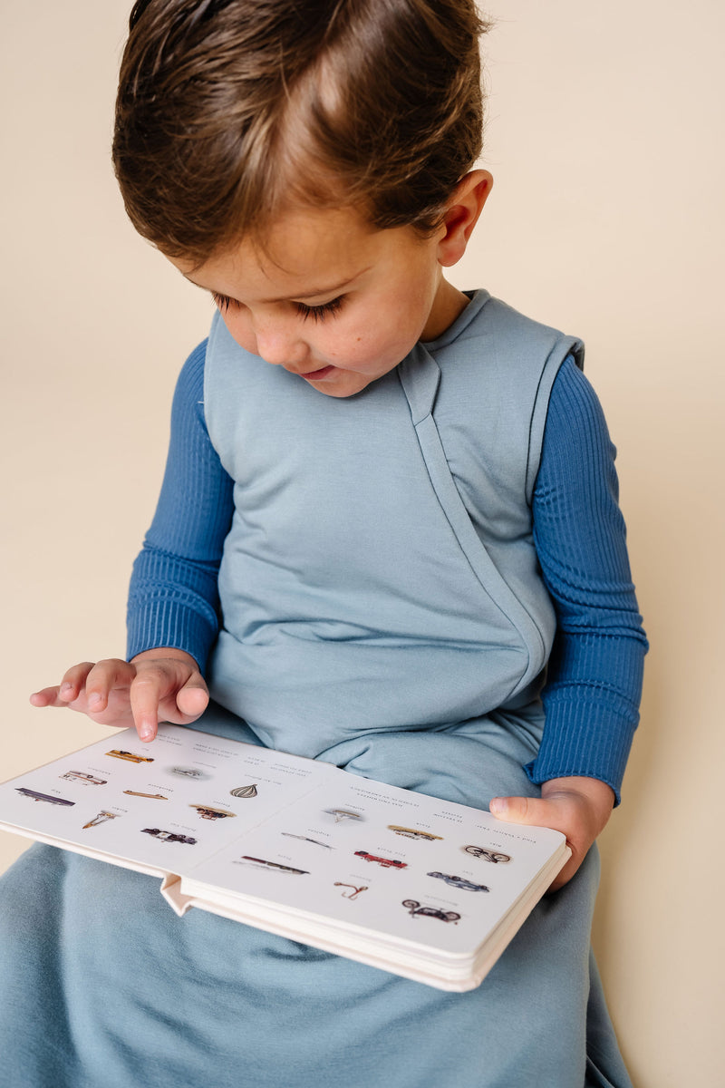 leo sleep sack toddler boy close up on leo fabric sitting down reading a book