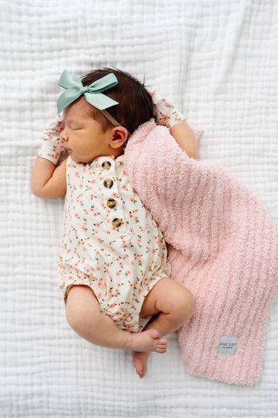 lottie bubble romper newborn girl holding blush chenille with matching mittens and sage satin bow