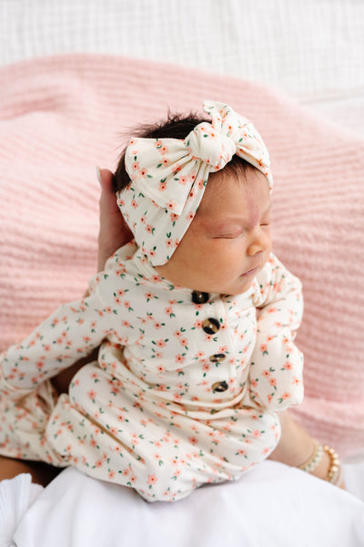 lottie headband and knotted gown newborn girl with blush chenille in the background