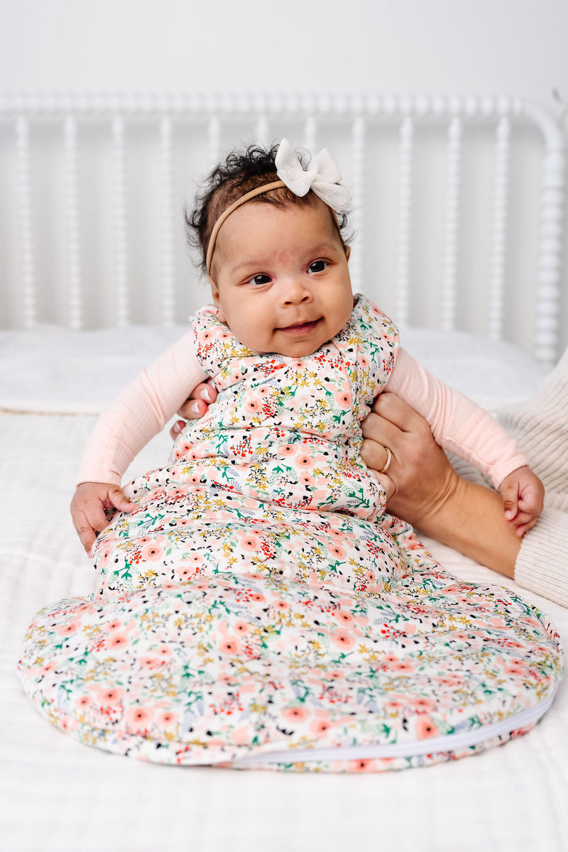 millie sleep sack newborn girl  sitting on bed being held up by Karen